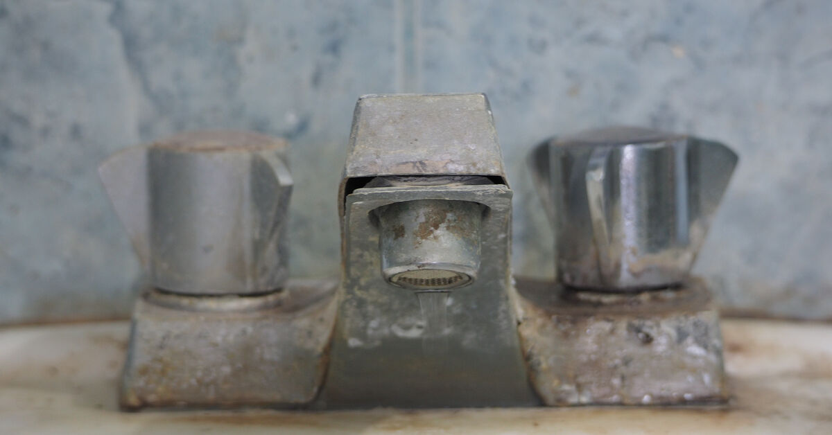 Limescale deposits around bathroom faucet base