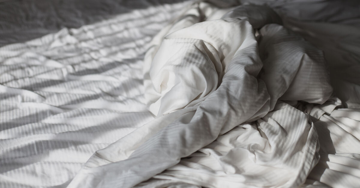 Unmade bed in dusty bedroom
